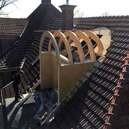 Ein dunkles Dach mit einer angebauten Holzrahmenstruktur.