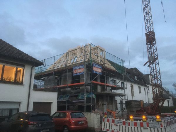 Ein im Bau befindliches Haus mit Gerüst und Kran, das die Bauarbeiten unterstützt und den Fortschritt zeigt.