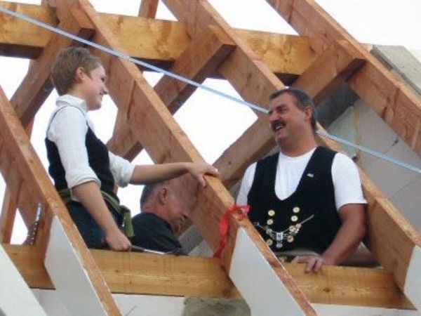 Drei Mitarbeiter die an einen Dachstuhl arbeiten.