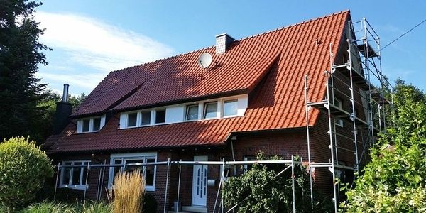 Ein Mehrfamilienhaus mit roten Dachziegeln.