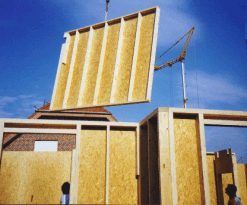 Ein Kran hebt eine Holzplatte an