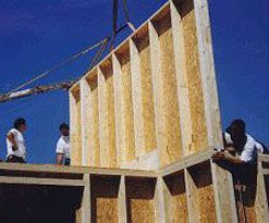 Mitarbeiter bringen die Holzplatten für das Holzrahmenhaus an