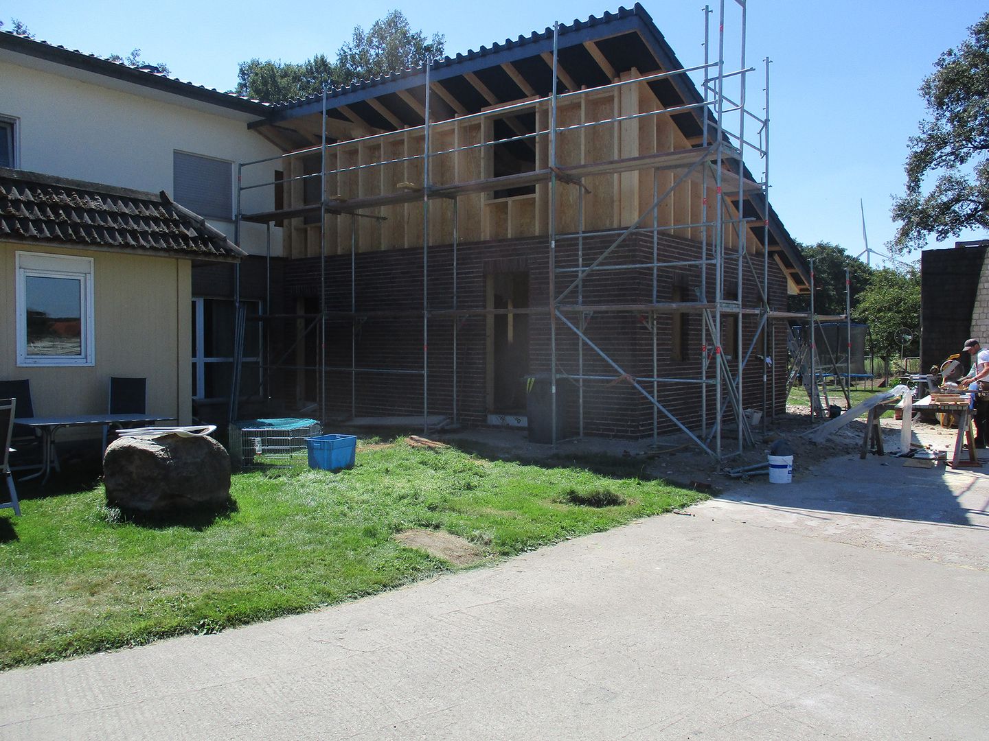 Großes Haus mit einem markanten Dach, umgeben von einer gepflegten Landschaft.