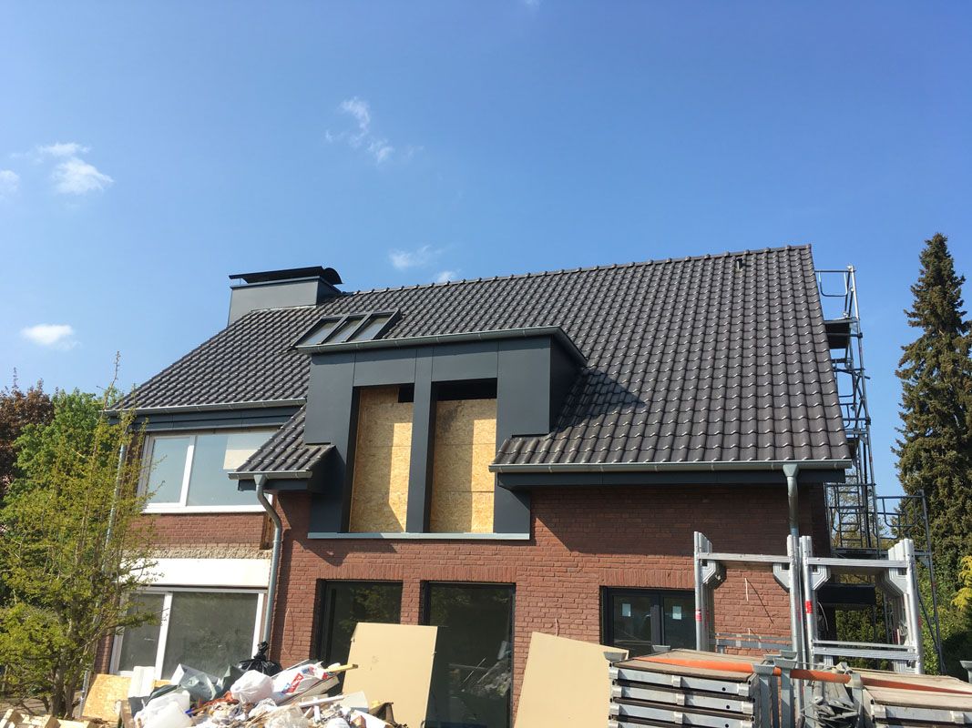 Ein weitläufiges Wohnhaus, wo die Fassade erneuert wird mit Handwerkern und Materialien in der Nähe.