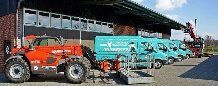 Mehrere Lastwagen stehen vor dem Firmengebäude geparkt und bilden eine lebhafte Kulisse.
